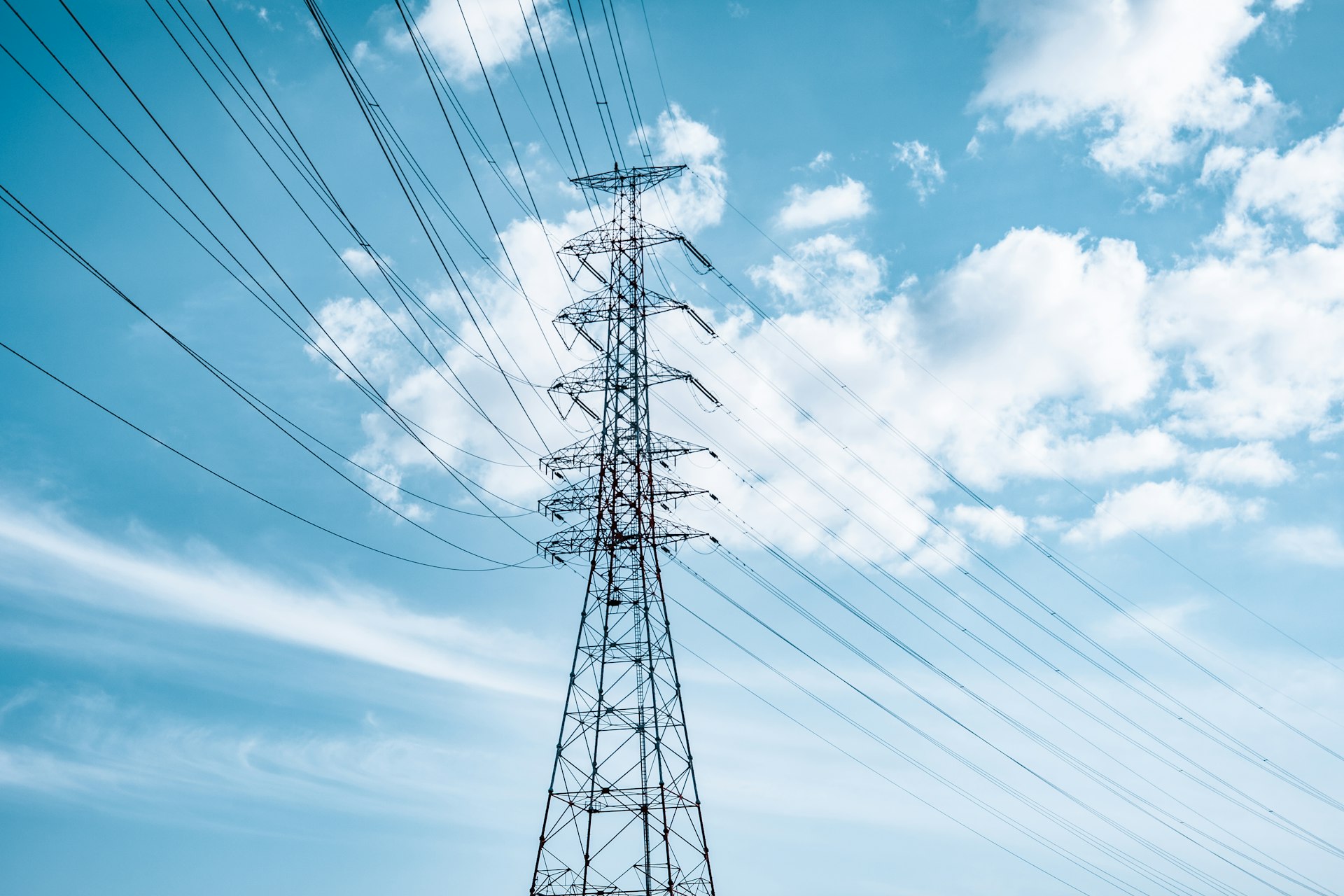 black electric tower under blue sky and white clouds during daytime